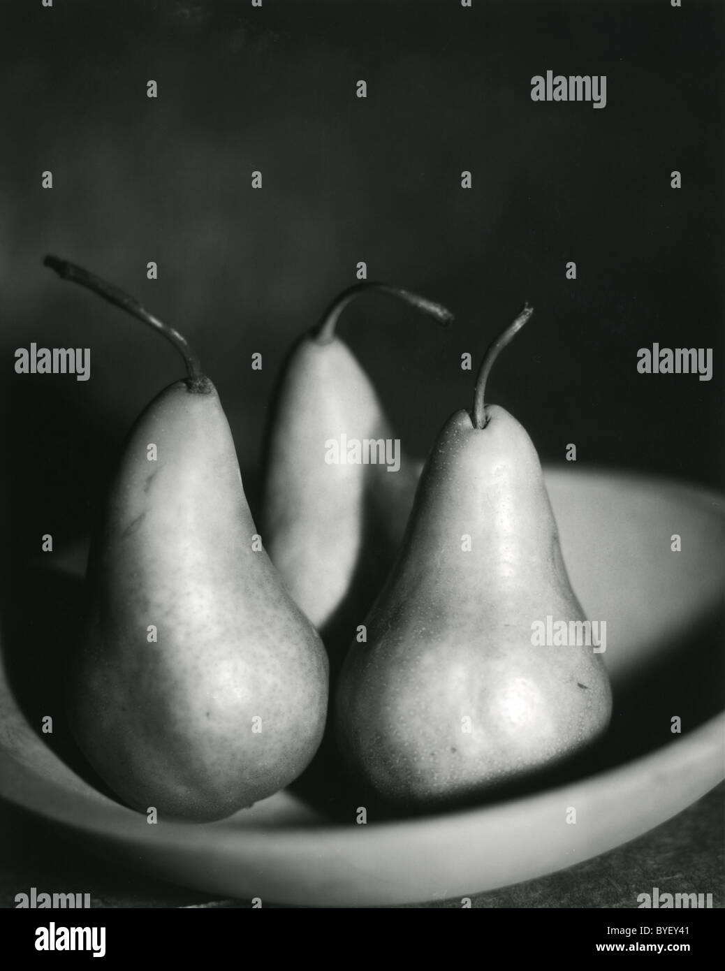 schwarz / weiß Foto von drei Birnen in einer Holzschale Stockfoto