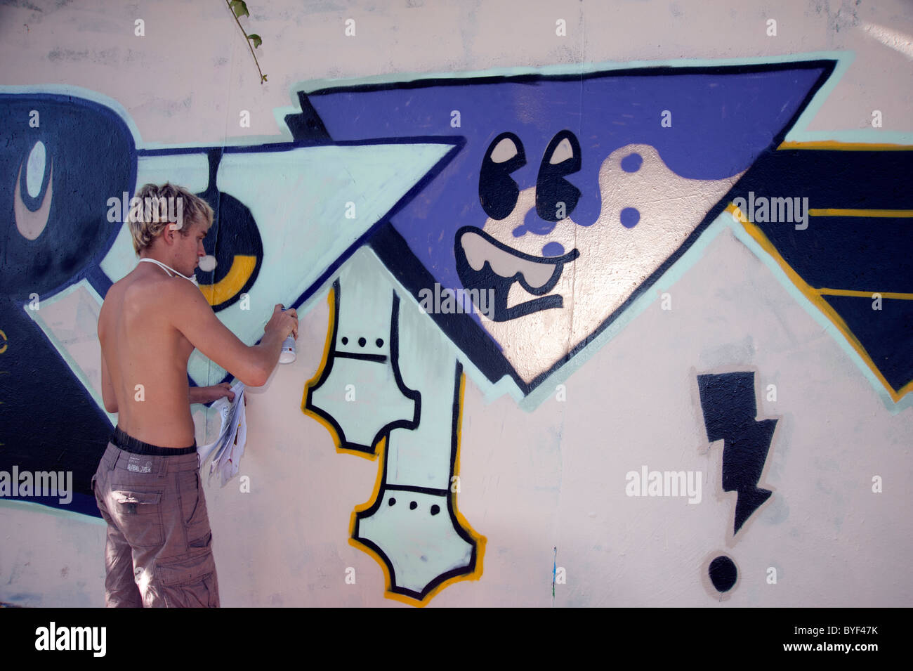 eine junge Künstlerin, die Graffiti Kunst auf öffentlichen Gebäuden macht Stockfoto