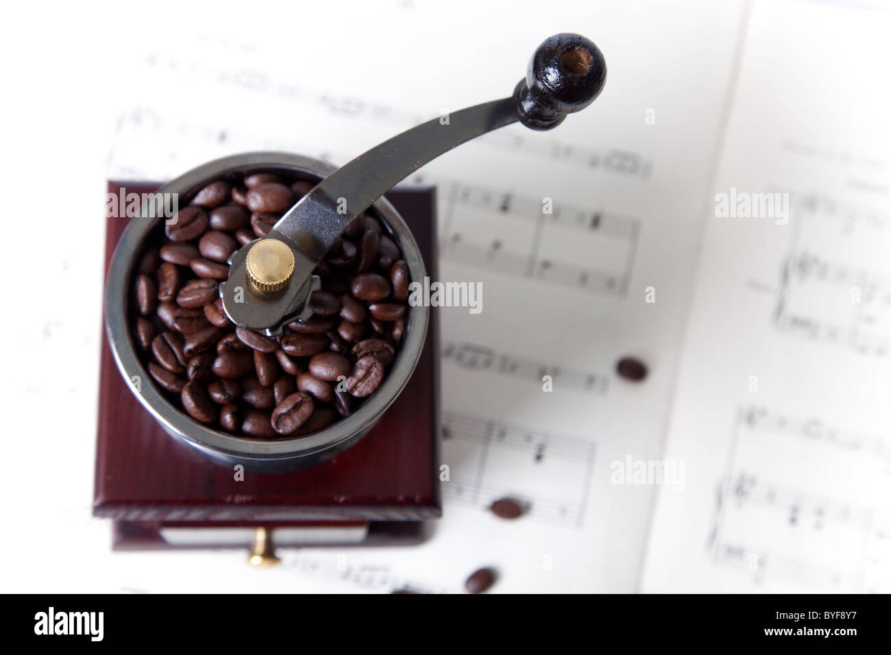 Kaffeemühle mit Kaffeebohnen zu den Noten Stockfoto