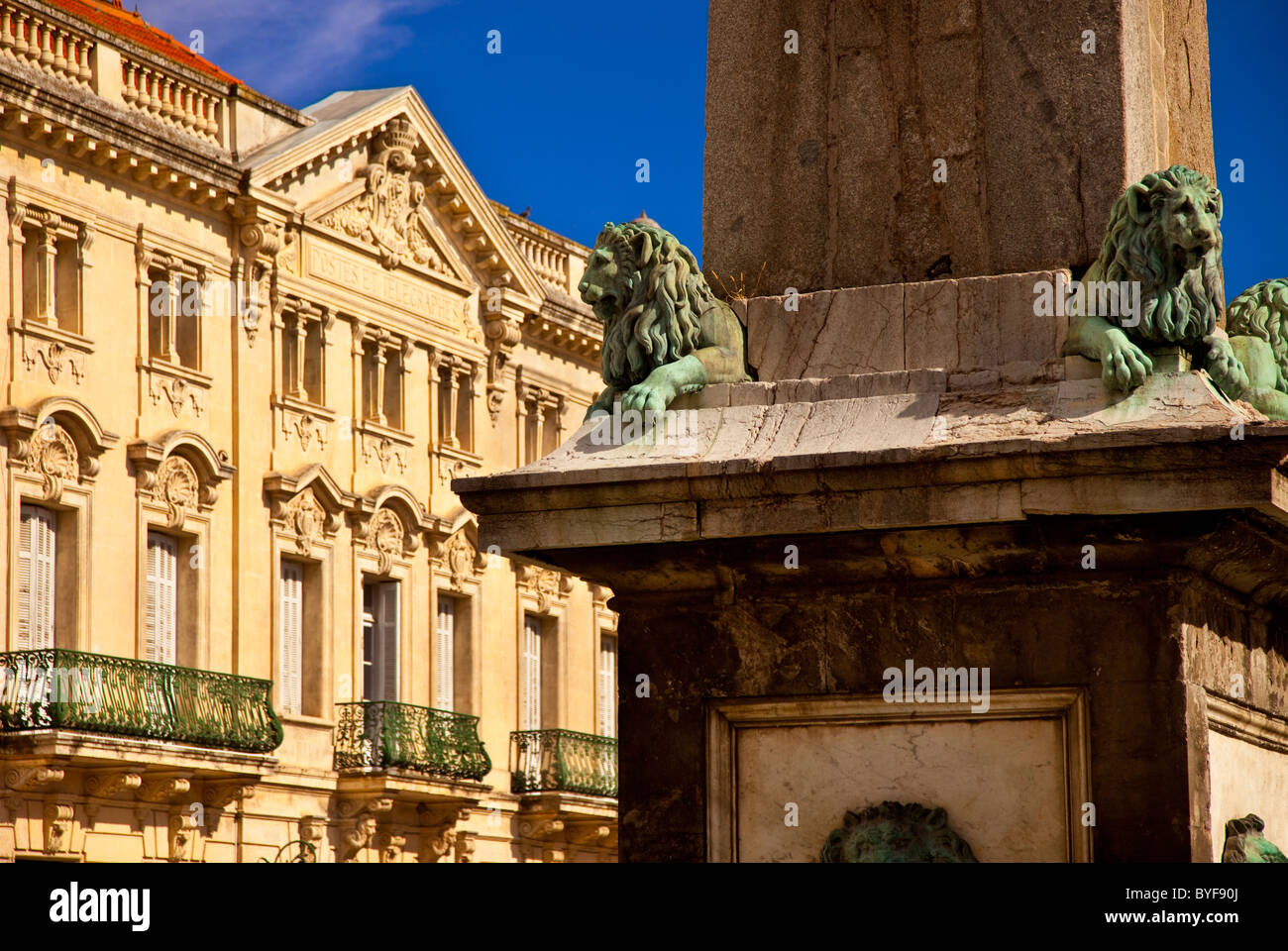 Lion Detail am Brunnen Obelisk mit den umliegenden Gebäuden - Place De La République in Arles, Provence Frankreich Stockfoto