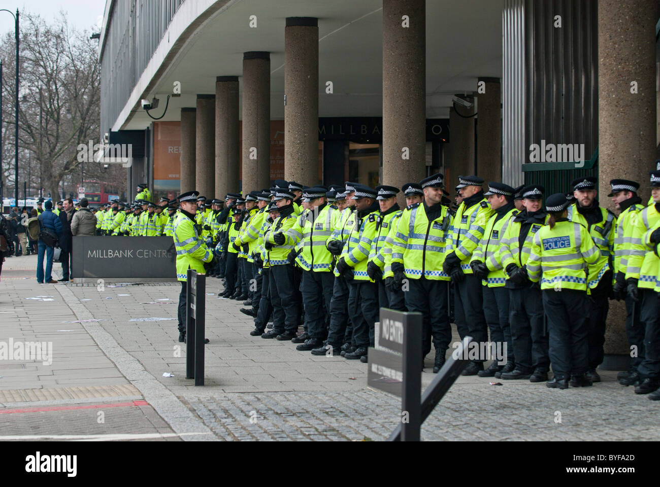Lange Linie Polizisten schützen konservative HQ Millbank Zentrum von Studierenden und Lehrenden Demonstranten auf Bildung schneidet März Stockfoto