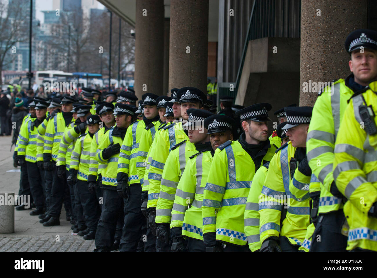 Lange Linie Polizisten schützen konservative HQ Millbank Zentrum von Studierenden und Lehrenden Demonstranten auf Bildung schneidet März Stockfoto