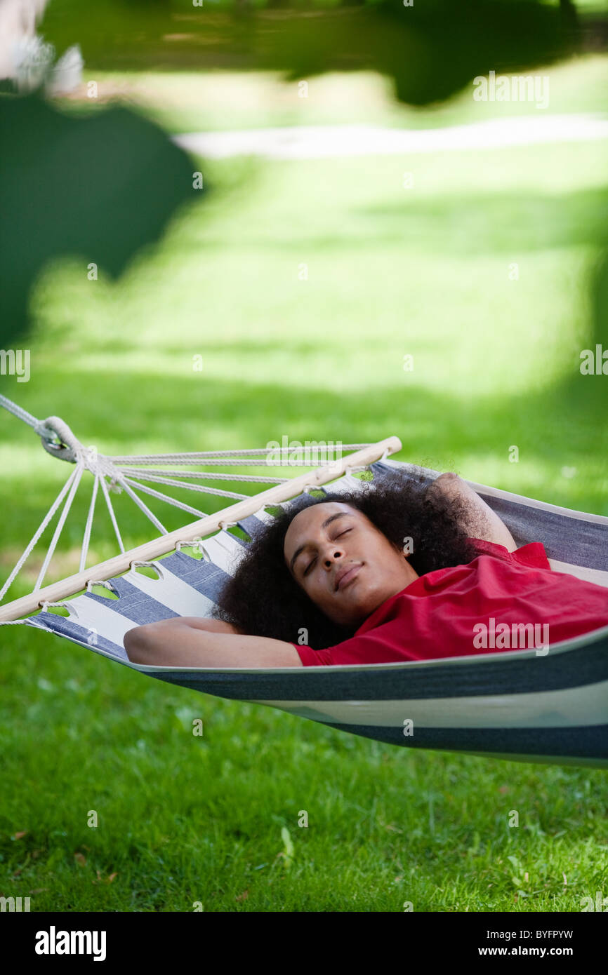 Junger Mann mit Afro Haaren schlafen in der Hängematte im park Stockfoto