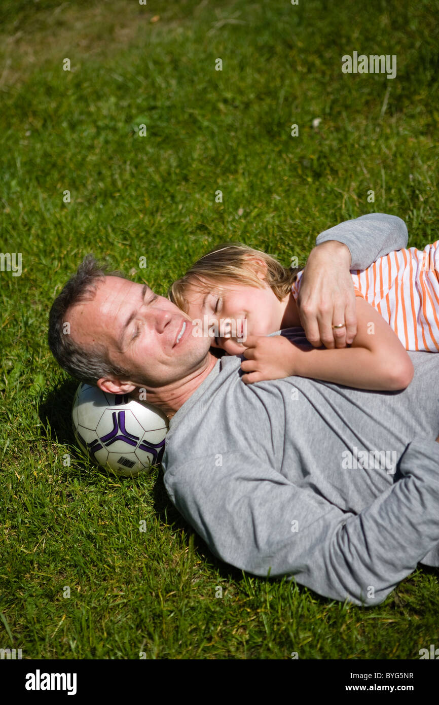 Vater mit Sohn auf dem Rasen liegend Stockfoto
