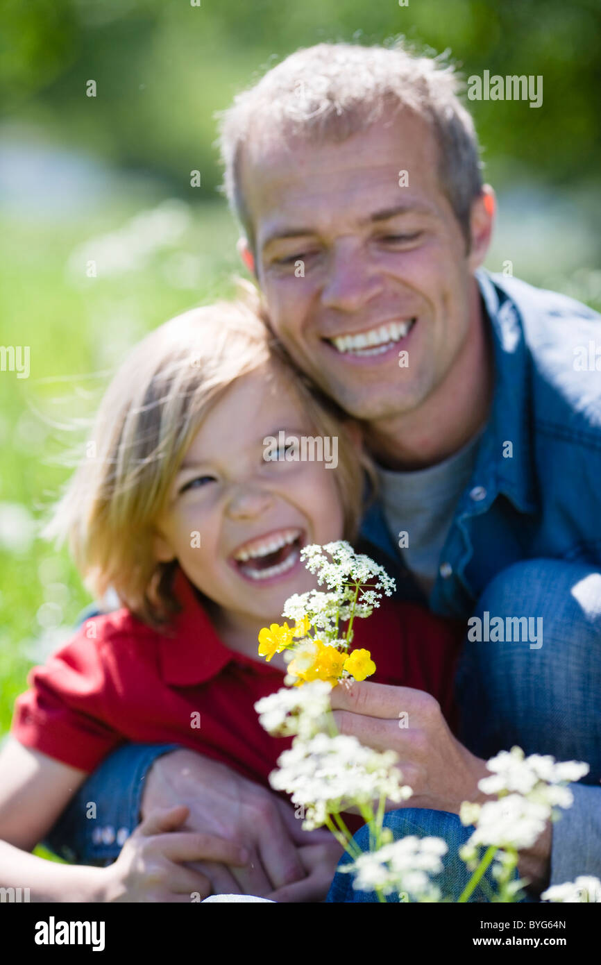 Vater und Sohn mit Blüten in hellem Sonnenlicht Stockfoto