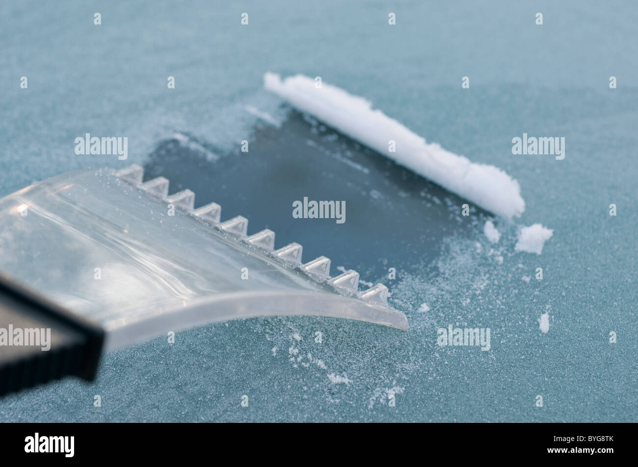 Schaben Eis von Windschutzscheibe mit Eiskratzer Stockfoto