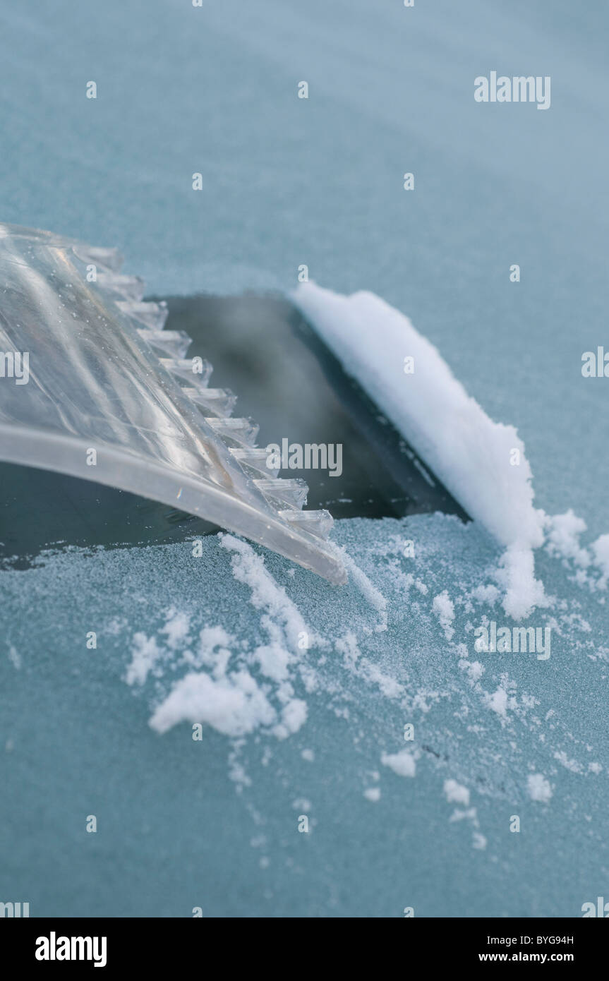 Schaben Eis von Windschutzscheibe mit Eiskratzer Stockfoto