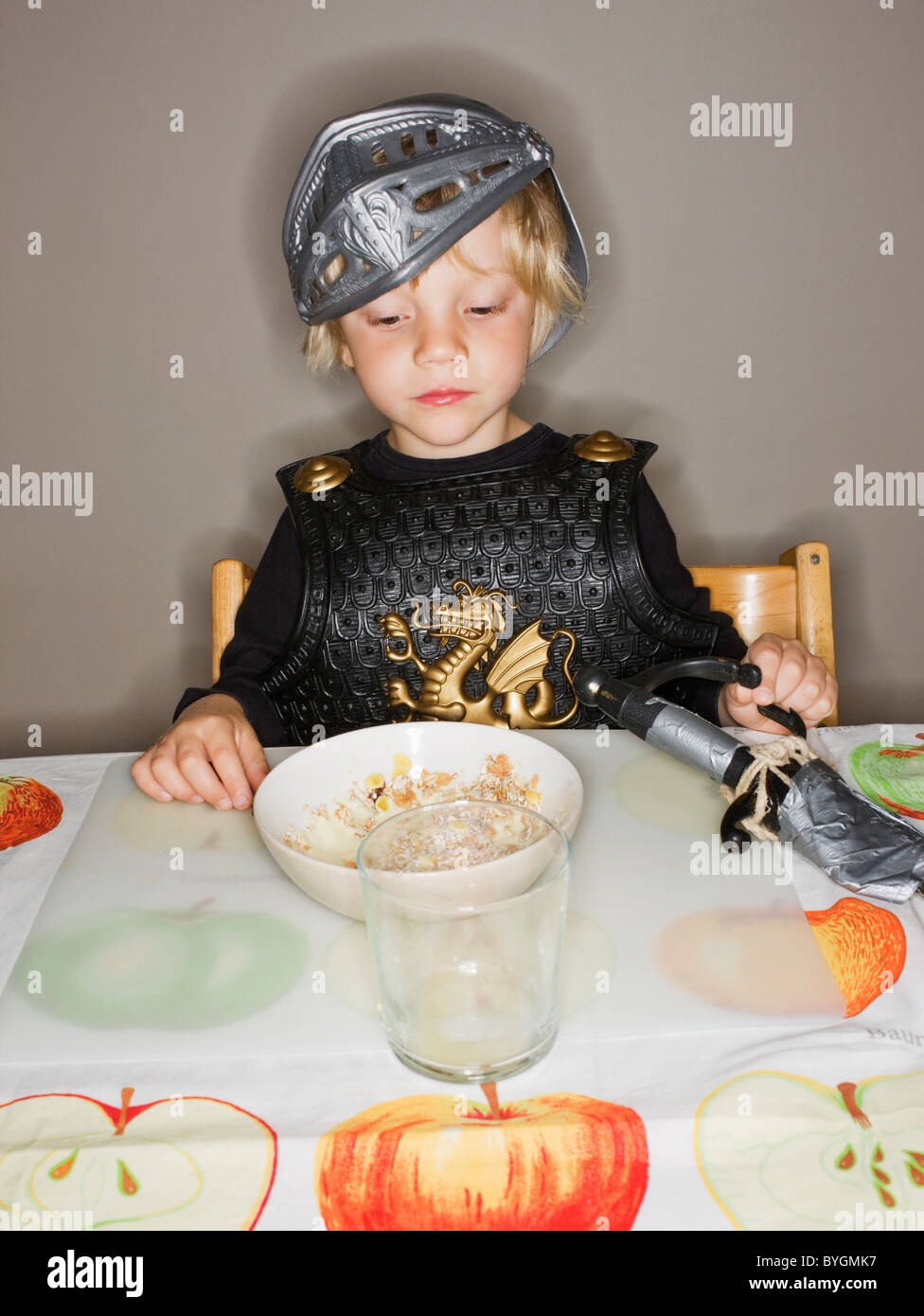 Junge in Rüstung Anzug Blick auf Frühstück Stockfoto