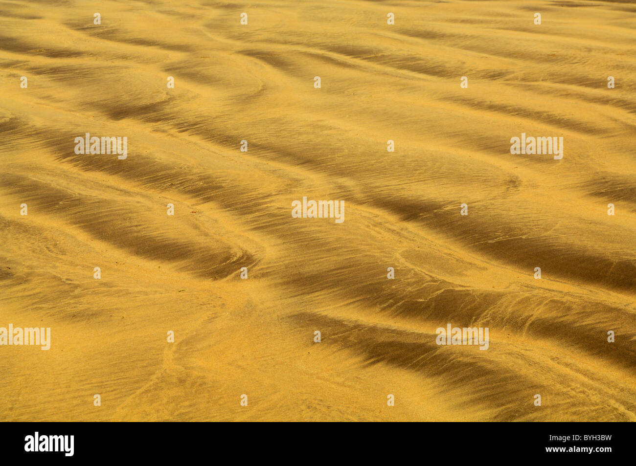 Muster in den Sand von der zurückweichenden Flut am Strand links. Stockfoto