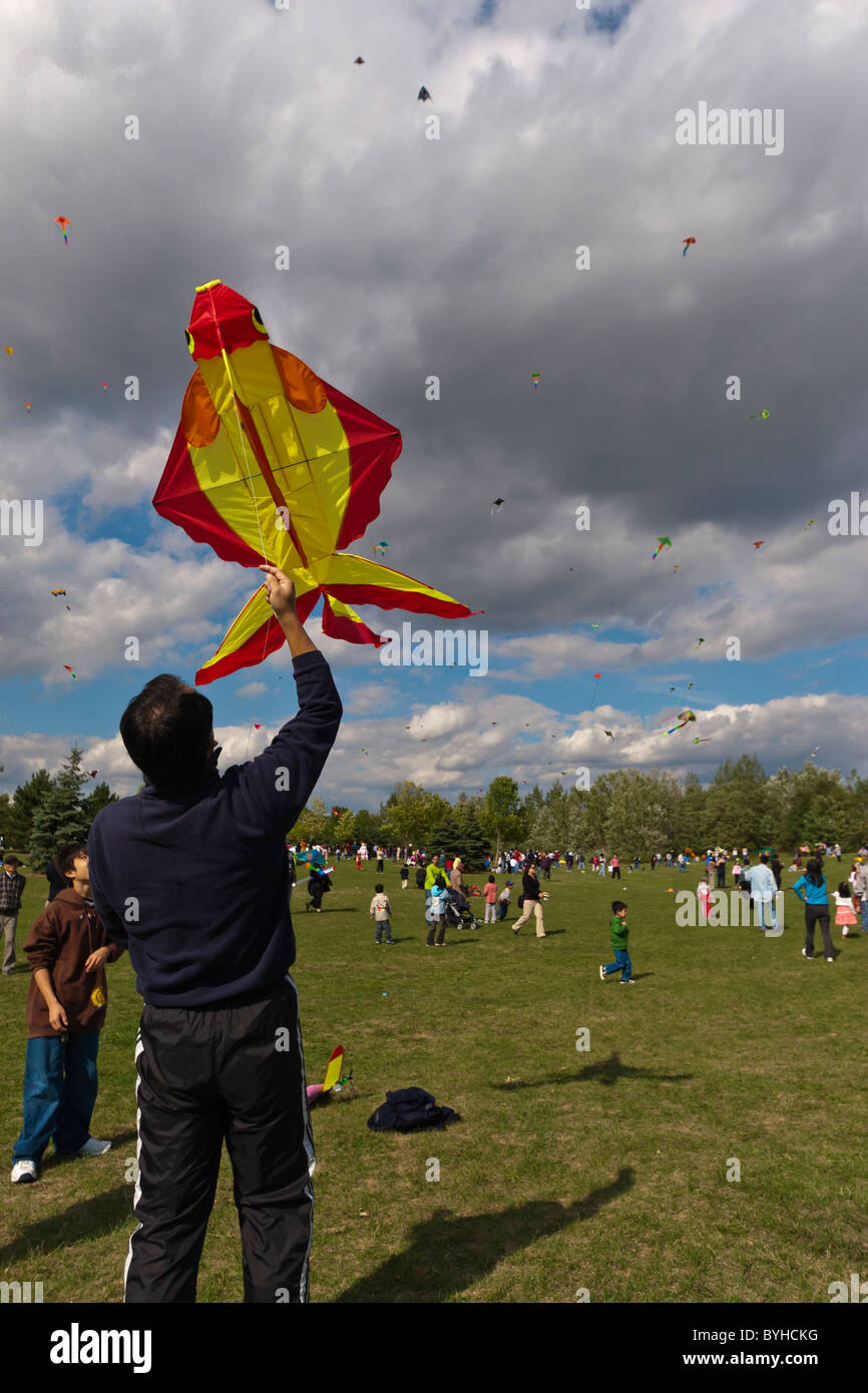 Mann immer bereit, einen Drachen zu fliegen, wie junge, während ein Kite Festival in Toronto, Kanada zusieht Stockfoto