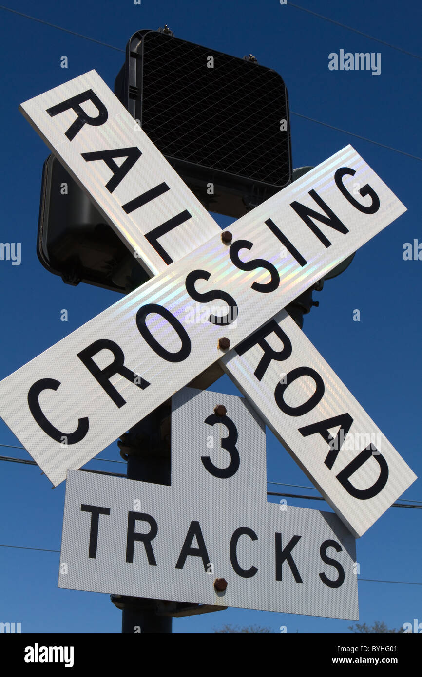 Bahnübergang Zeichen mit drei Tracks vor blauem Himmel. Stockfoto