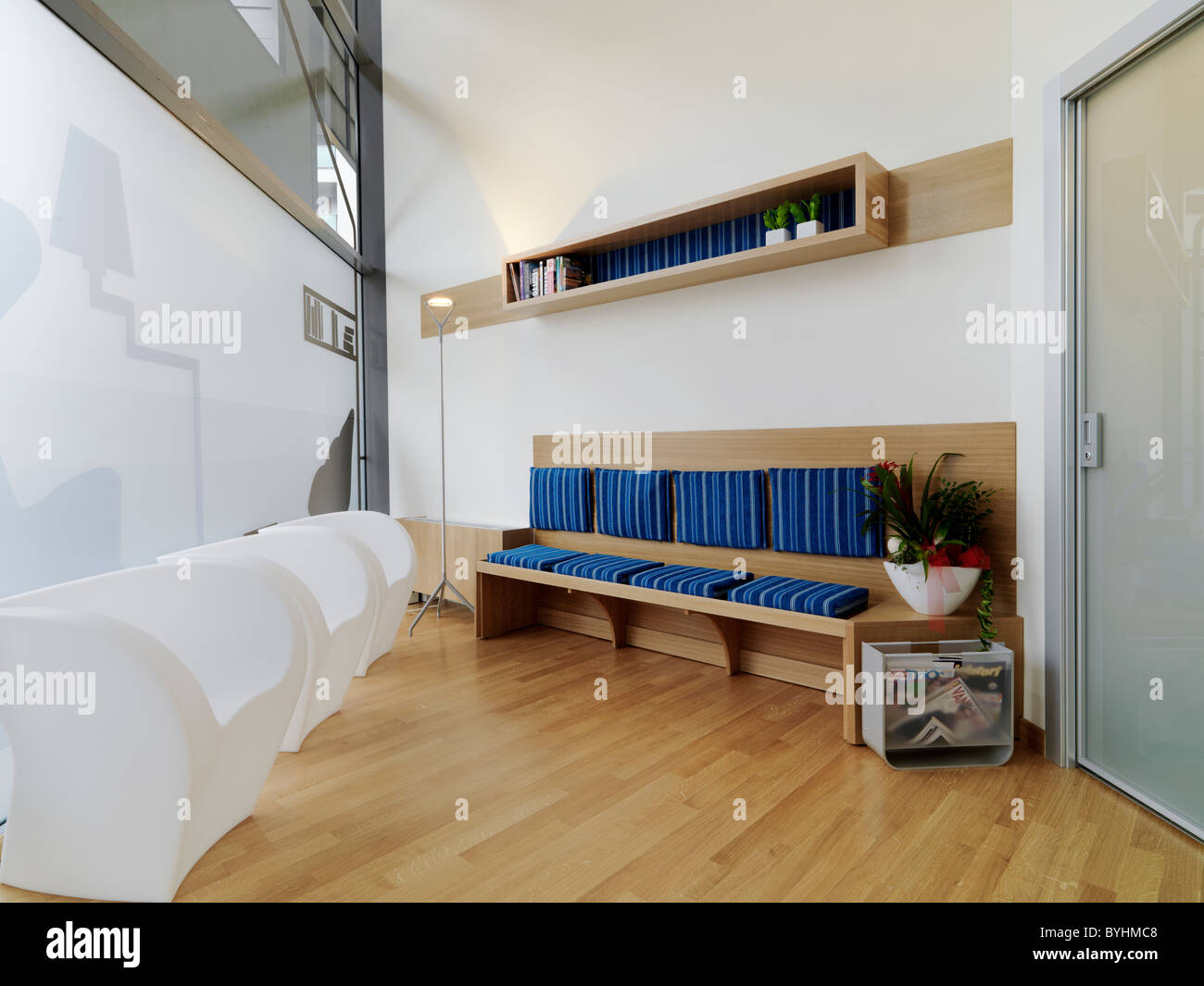 weiße Kunststoff-Sessel und Sofa in einem modernen Wartezimmer mit Holzboden Stockfoto