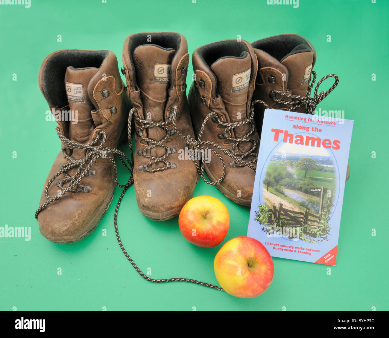 Wandern zum Vergnügen entlang der Themse Reiseführer mit zwei Paar Wanderschuhe im Studio mit grünem Hintergrund genommen - Berkshire, UK Stockfoto