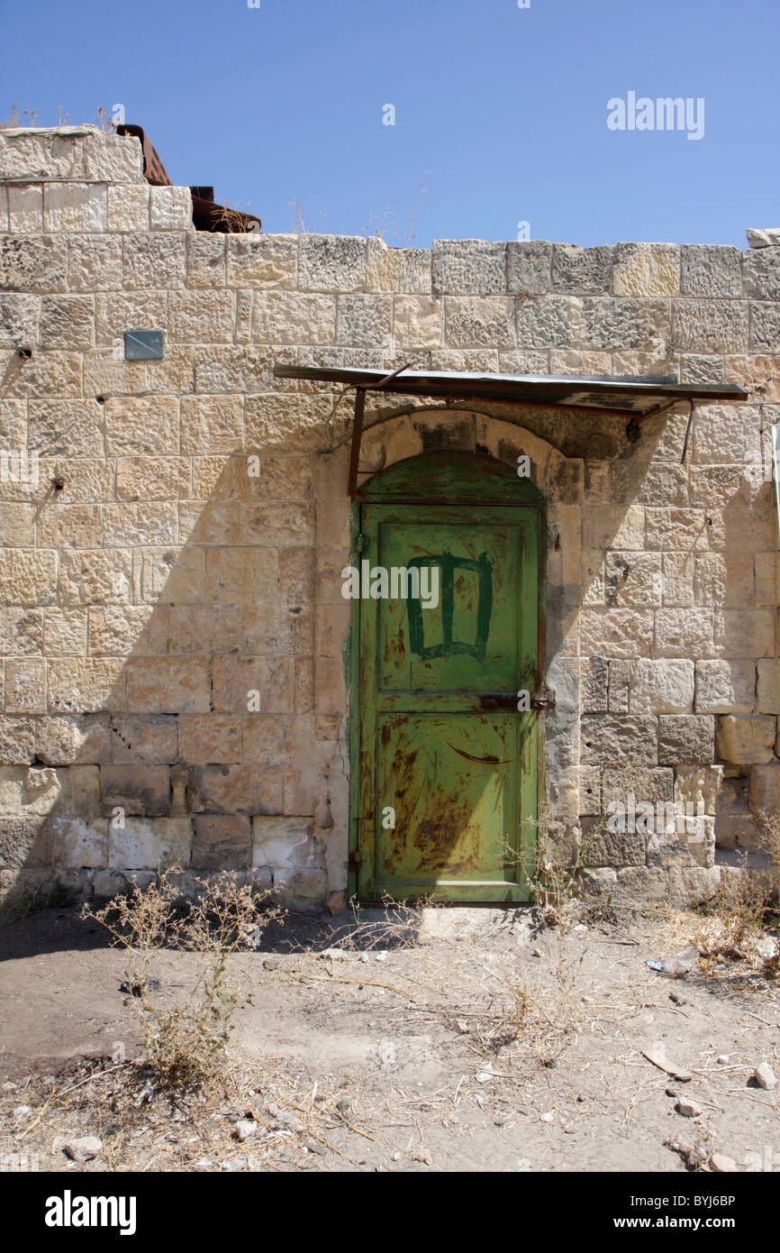 Eine grüne Tür zeichnet sich auf den Ruinen eines palästinensischen Shops auf Shuhada Straße in der Stadt Hebron. Stockfoto