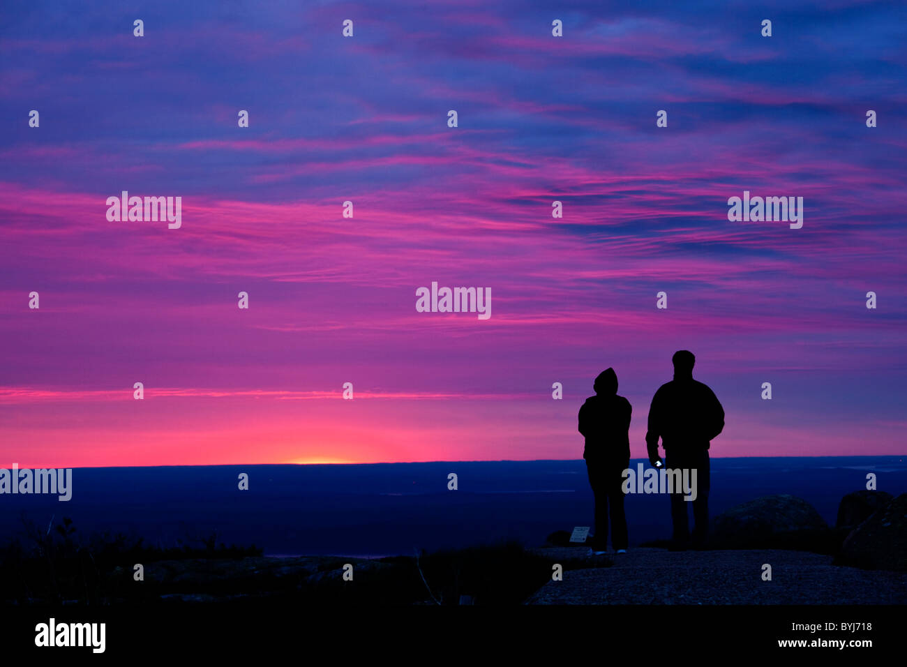 USA, Maine, Acadia National Park, Silhouette des Paares gerade Sonnenaufgang am Gipfel des Cadillac Mountain an kühlen Sommermorgen Stockfoto