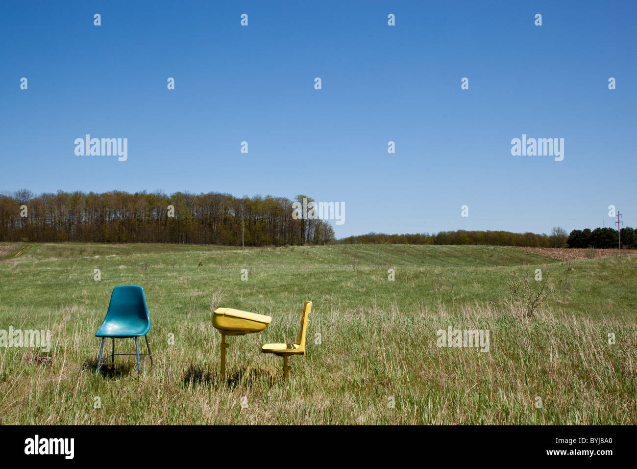 USA, Michigan, Hillman, verlassene Schule Schreibtisch und Stühle im Bauern Feld Frühlingsmorgen Stockfoto