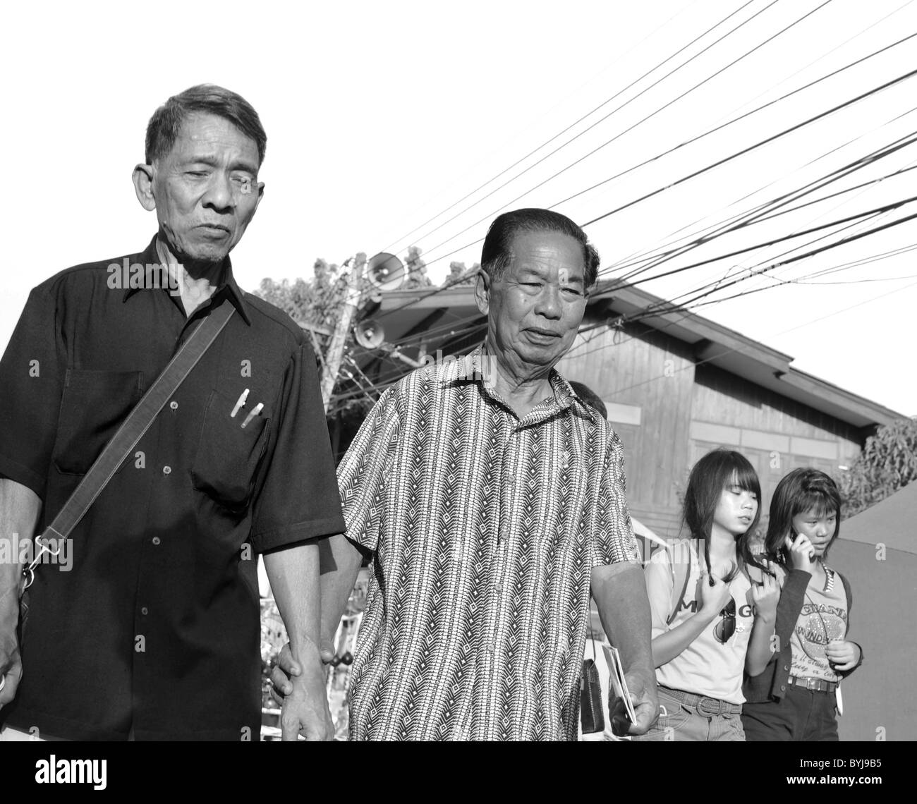 Schwarz / weiß Foto von zwei Thai Männer zu Fuß entlang einer Straße Stockfoto