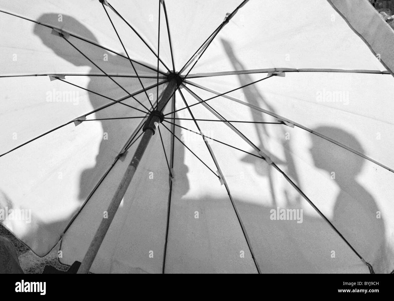 Schwarz / weiß Fotografie von Menschen Schatten auf einem großen Sonnenschirm Stockfoto