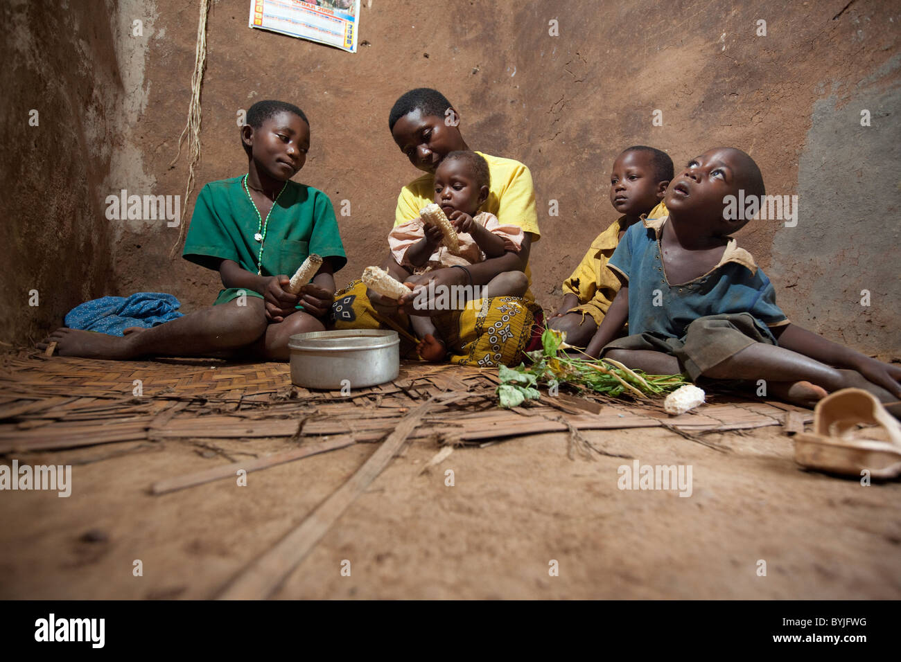 Eine Familie teilt eine Mahlzeit zusammen in ihre Heimat in Masaka, Uganda, Ostafrika Schlamm. Stockfoto