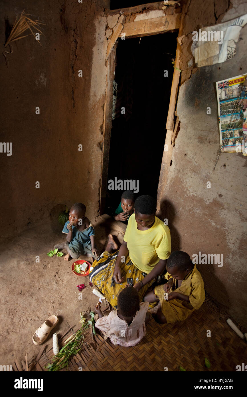 Eine Familie teilt eine Mahlzeit zusammen in ihre Heimat in Masaka, Uganda, Ostafrika Schlamm. Stockfoto