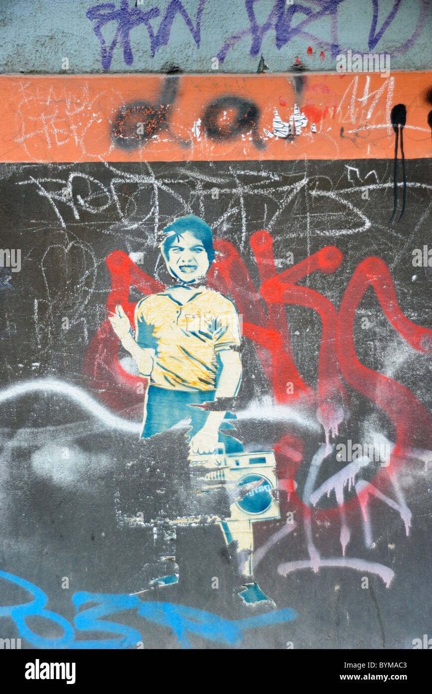 Streetart-Tapete mit einem jungen und einem Ghettoblaster an einer Graffitiwand in Berlin. Stockfoto