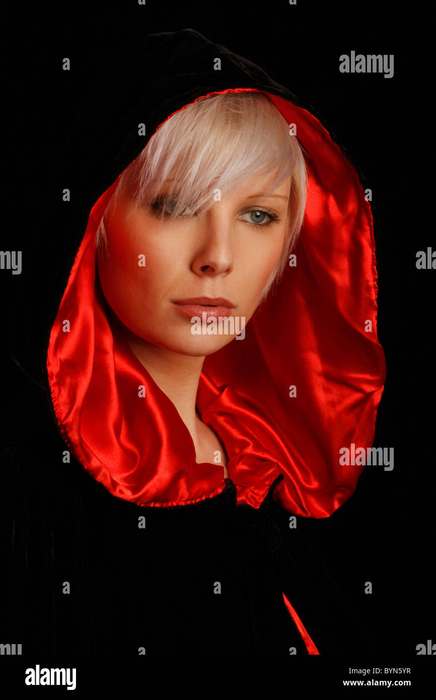 junge Silber dunkelhaarige Frau trägt ein rotes ausgekleidet schwarzen Umhang Stockfoto