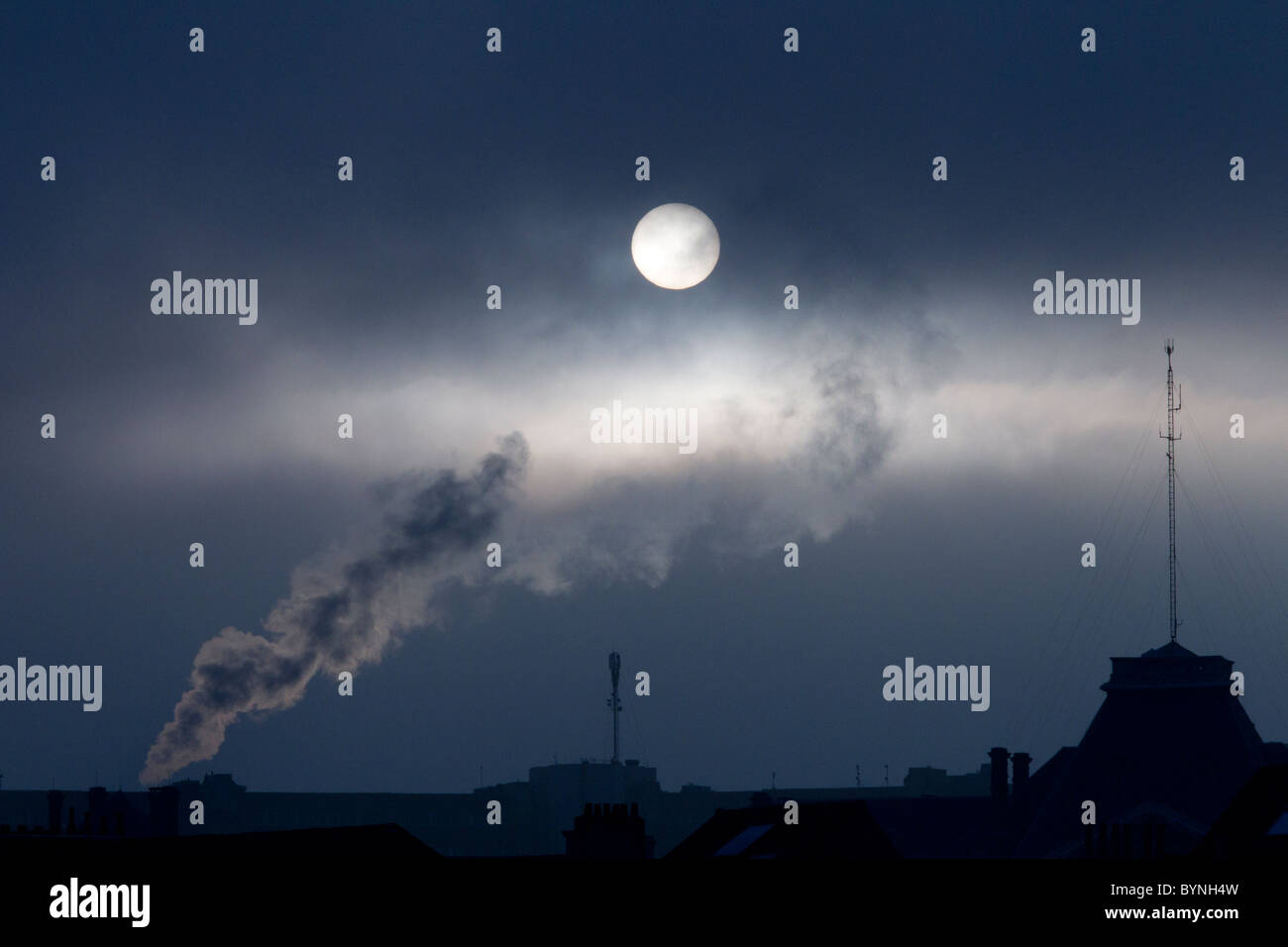 Rauchfahne sichtbar gegen dunklen Himmel durch den Vollmond oder Sonne beleuchtet Stockfoto