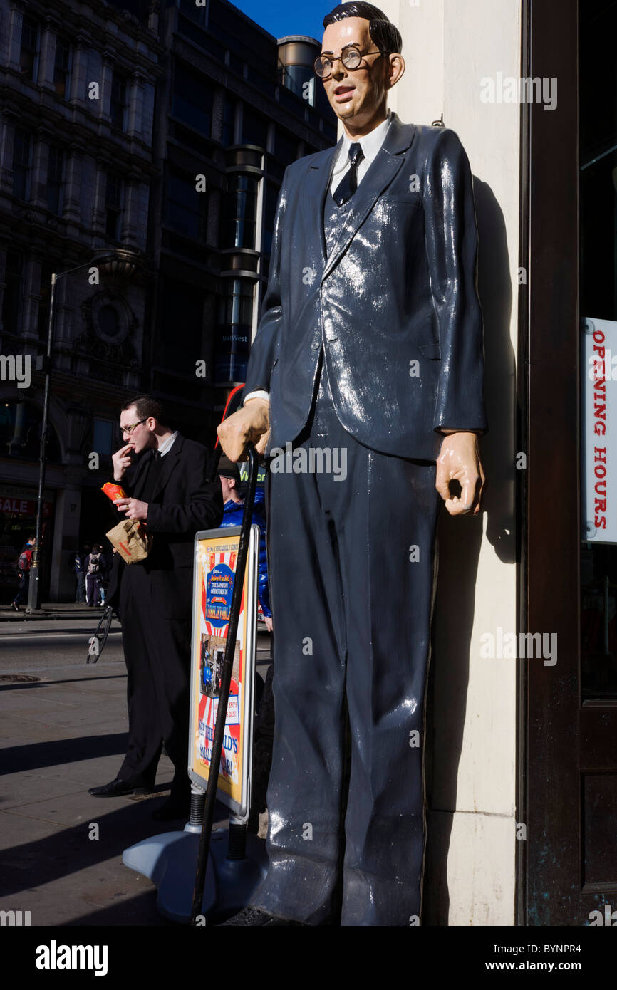 Scale Modell der weltweit größte Mann Robert Pershing Wadlow in London Straße mit ähnlich aussehenden Mann Essen Junk Food. Stockfoto