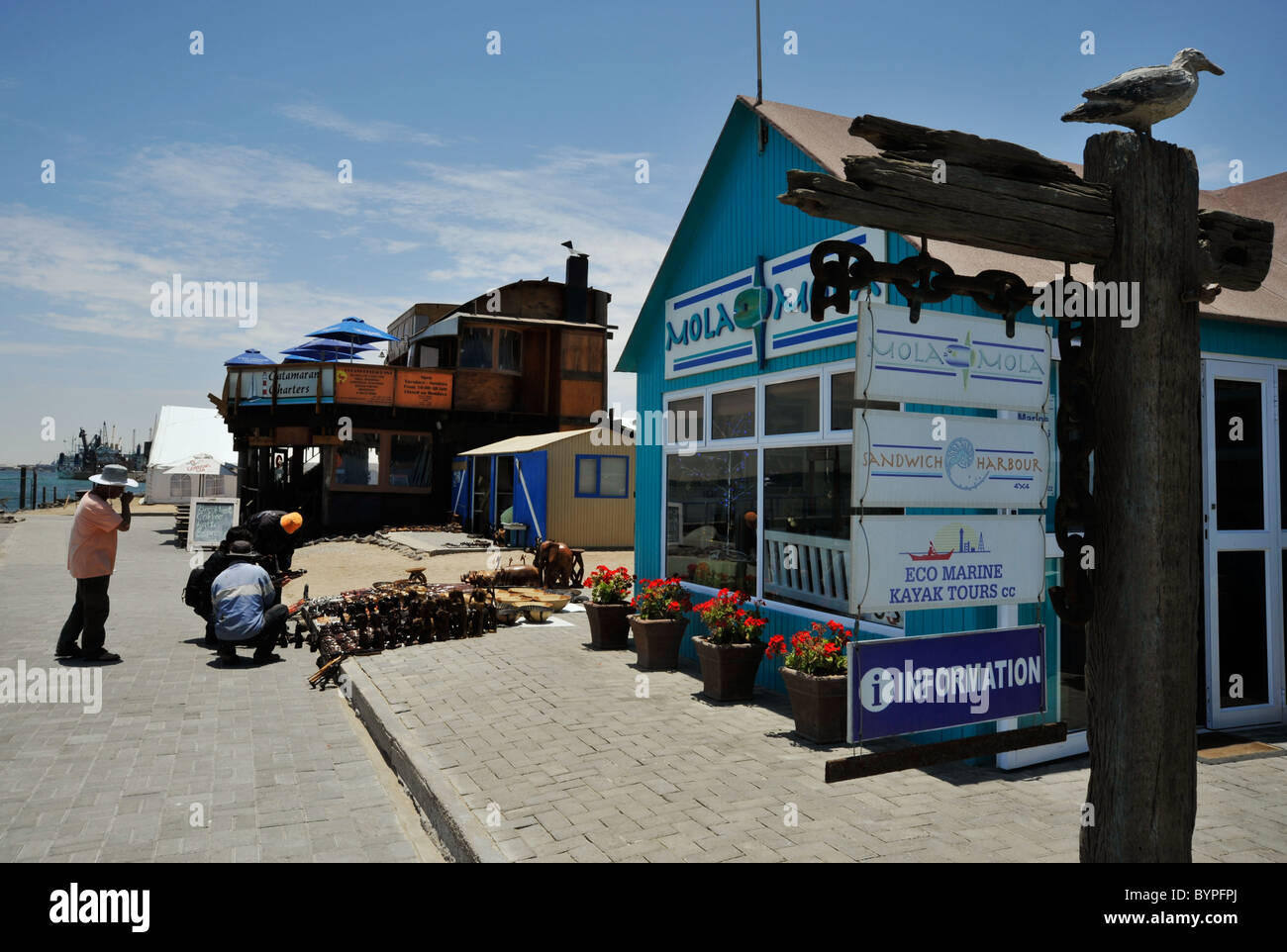 WalvisBay, Namibia, Menschen, Erwachsene Männer einkaufen für Touristen sehen am Hafen am Wasser, Gebäude Stockfoto