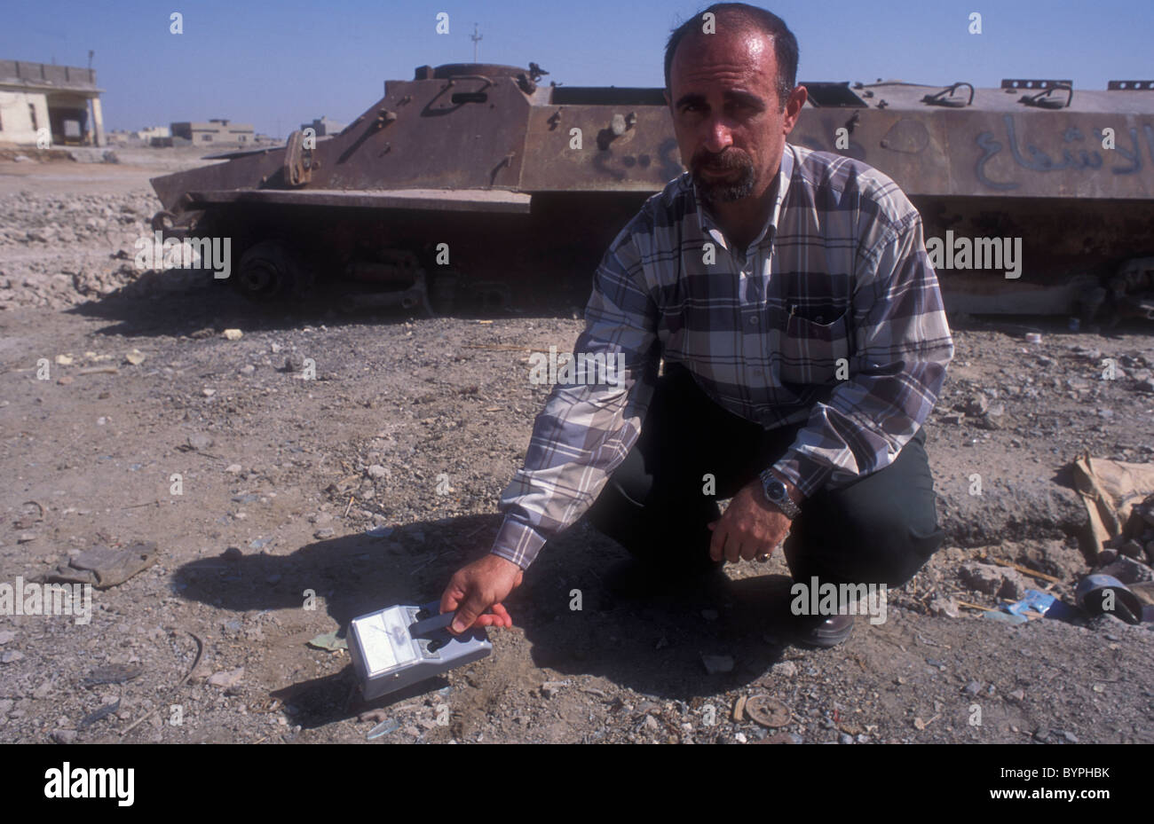Basra Irak 2004. Ein Wissenschaftler messen die Anwesenheit von Uran auf ein Geigerzähler neben den Überresten einer irakischen Truppentransporter Stockfoto