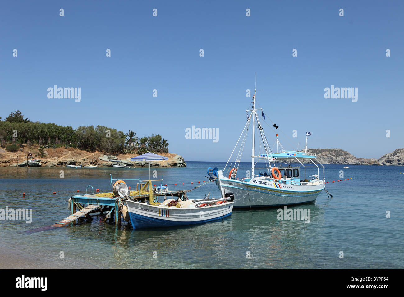 Boote vertäut im seichten Wasser am Strand von Agia Pelagia, Crete. Stockfoto