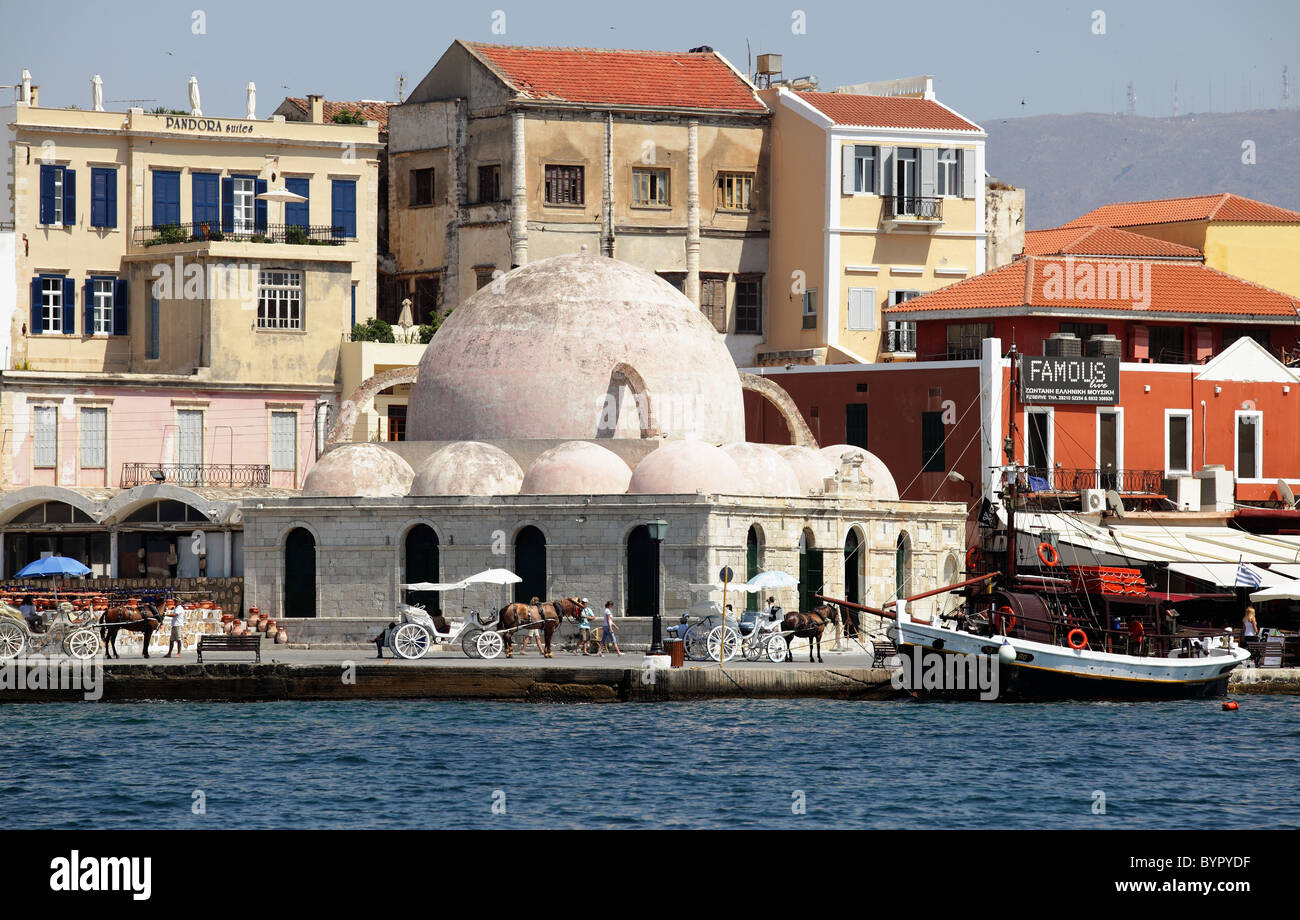 Das Kucjk Hassan Mosque oder Moschee der Janitscharen am Hafen Chania, Kreta, mit Pferdekutschen und ein Touristenboot Reise Stockfoto