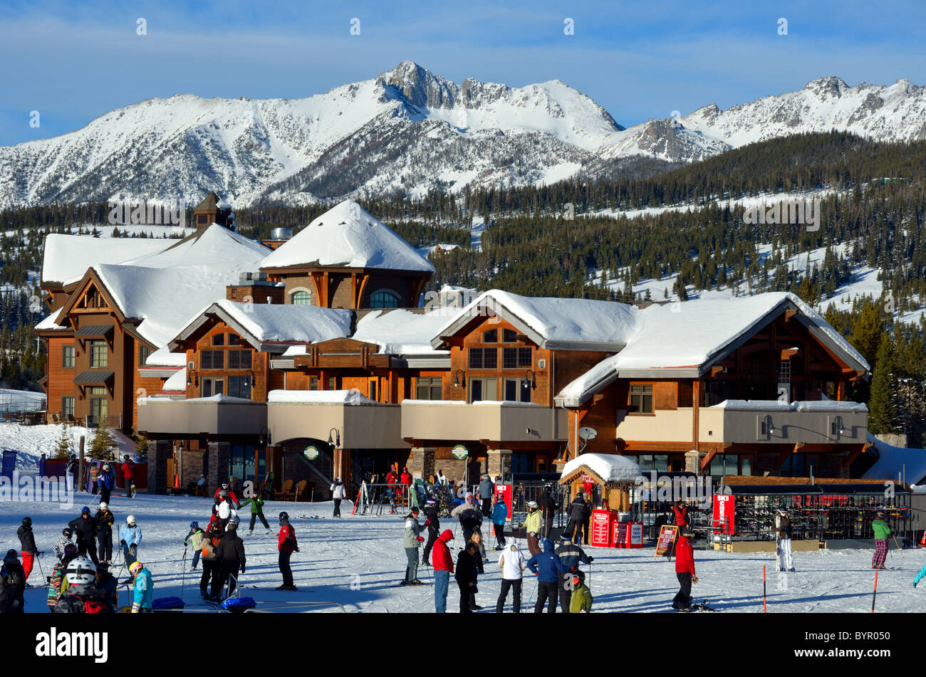 Skifahrer kommen den Hang hinunter zum Dorfzentrum. Big Sky Ski Resort, Montana, USA. Stockfoto