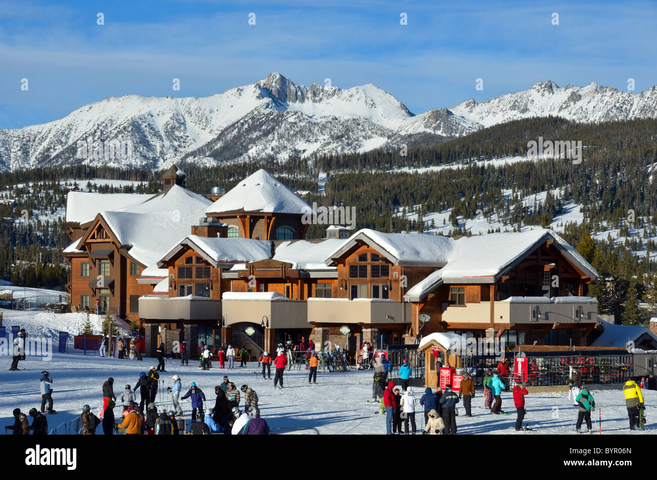 Skifahrer kommen den Hang hinunter zum Dorfzentrum. Big Sky Ski Resort, Montana, USA. Stockfoto