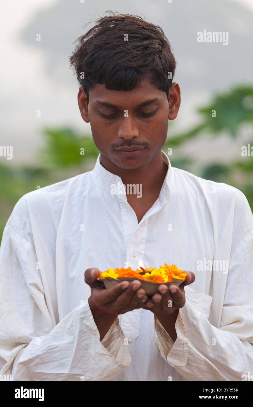 Indien, Uttar Pradesh, jungen hindu Mann, Gebet Lampe und Ringelblumen Stockfoto
