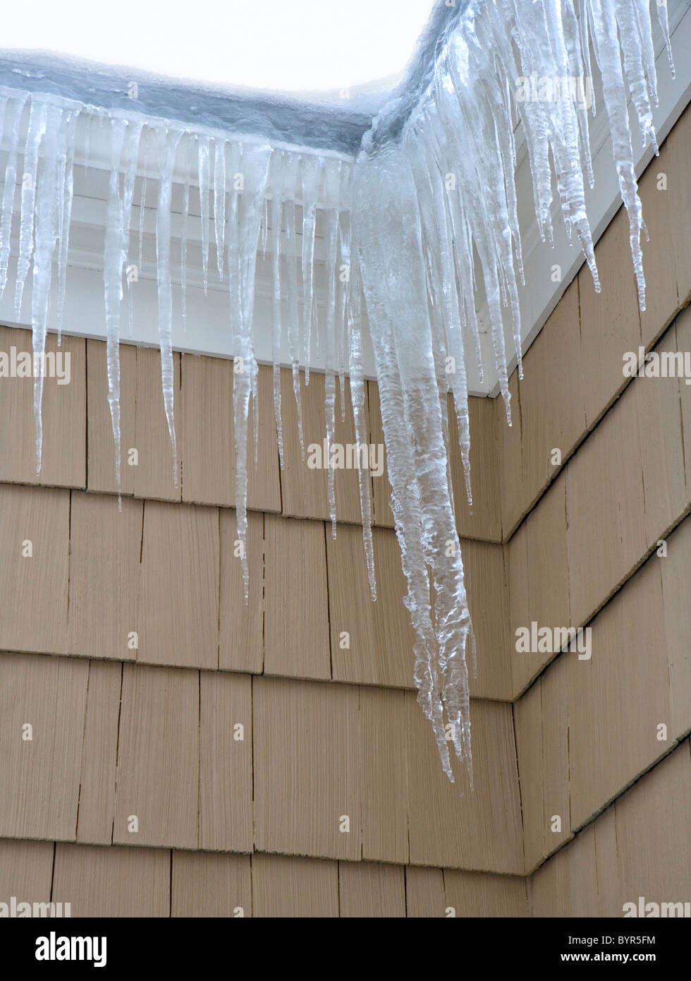 Eiszapfen Hand aus einem gefrorenen Bundsteg auf ein Haus im winter Stockfoto