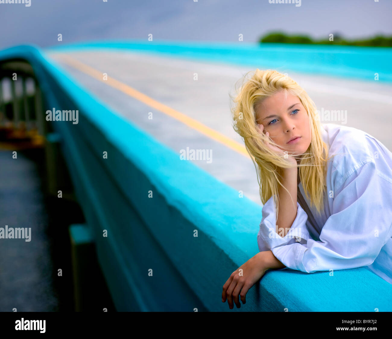 Junge blonde Frau auf der Brücke zu Tagträumen Stockfoto