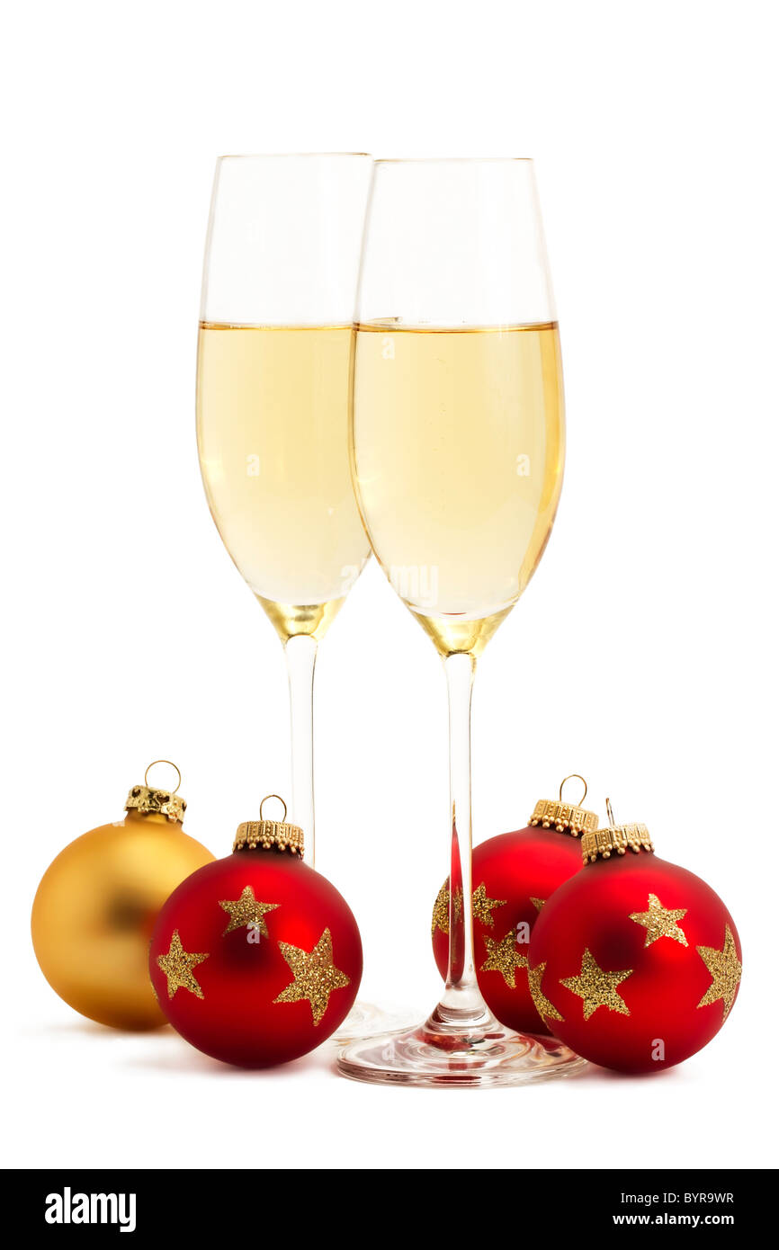 zwei Gläser mit Champagner mit einem goldenen und drei roten Weihnachtskugeln auf weißem Hintergrund Stockfoto