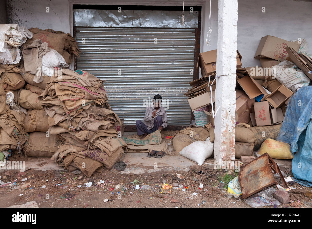 Indien, Rajasthan, Jodhpur Mann hessische Säcke zu reparieren Stockfoto