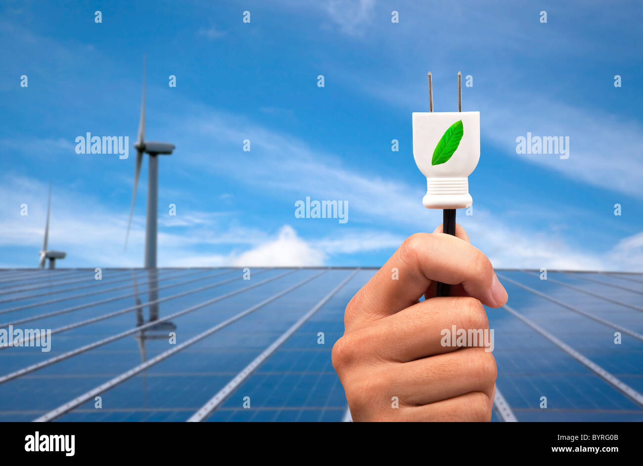 Eco Power concept.hand mit Ökostrom-Stecker und Solar-Panel und Wind-Turbine-Hintergrund Stockfoto
