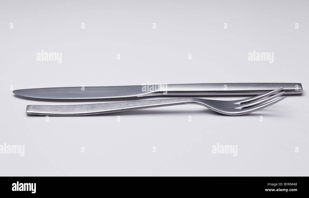Messer und Gabel aus modernen rostfreien Stahl Design isoliert gegen weiße und reflektierenden weißen Licht Stockfoto