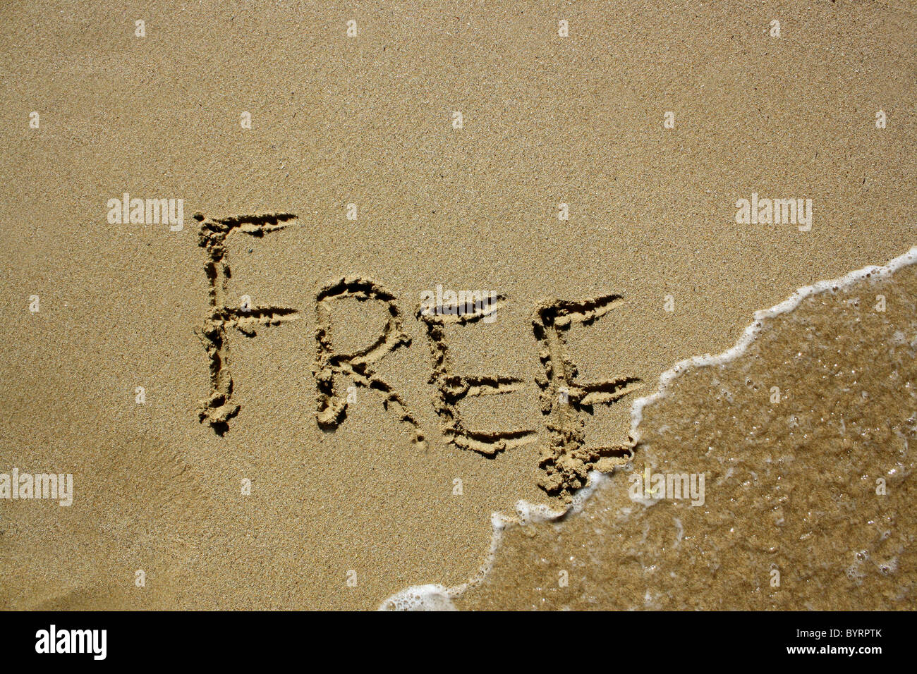"Frei" im nassen Sand geschrieben. Bitte siehe meine Sammlung ähnlicher Fotos. Stockfoto