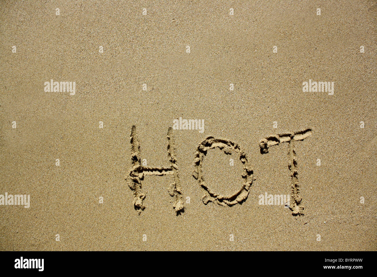 "Heiße" im nassen Sand ausgeschrieben. Bitte siehe meine Sammlung ähnlicher Fotos. Stockfoto