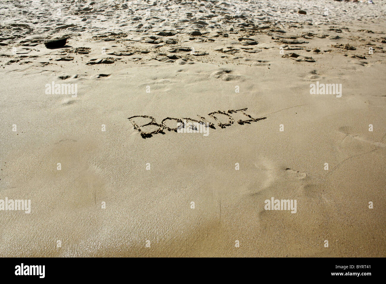 "Bondi" im nassen Sand ausgeschrieben. Bitte siehe meine Sammlung ähnlicher Fotos. Stockfoto