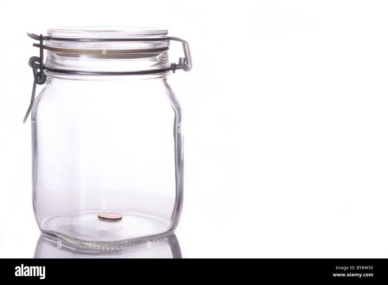 Anfang zu etwas Geld für später zu sparen, Münze auf der Unterseite von einem transparenten Glas jar isoliert auf weiss mit Textfreiraum. Stockfoto
