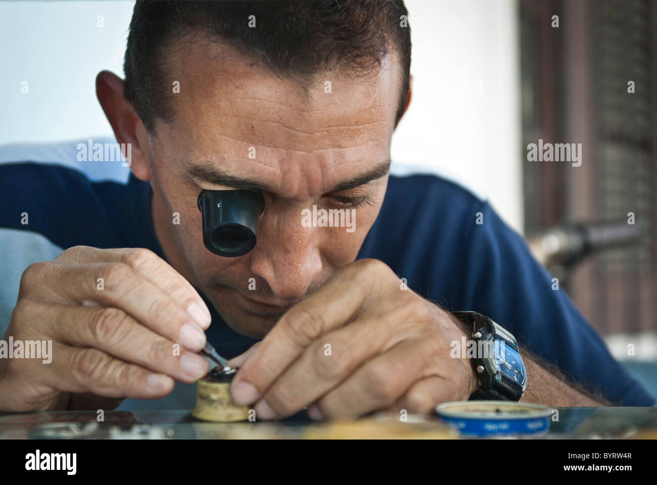 Mann, die Reparatur einer Uhrwerks mit einem Monokel. Santiago De Cuba, Kuba, Caribbean Stockfoto