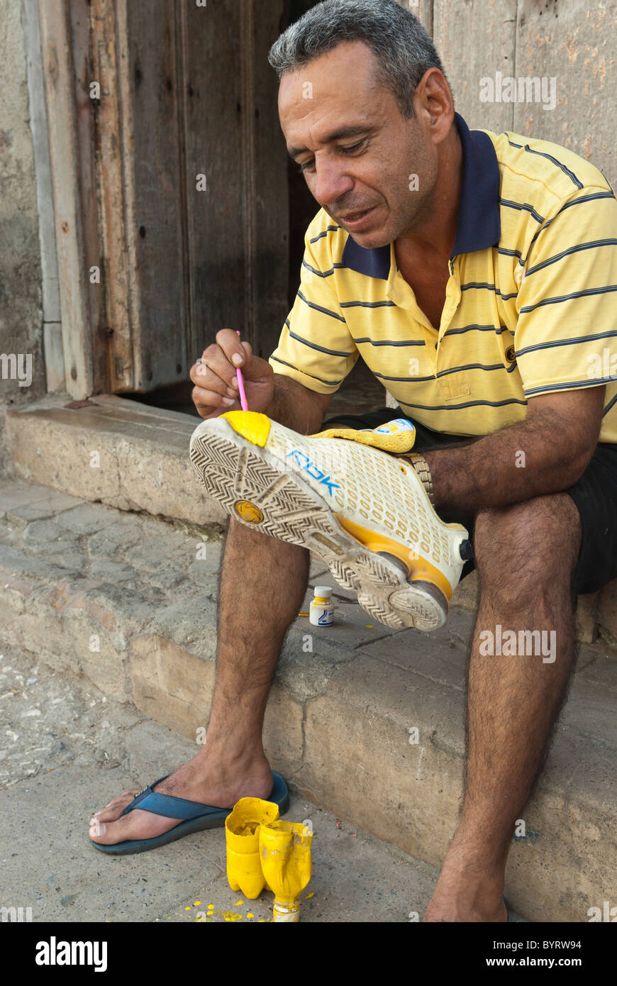 Mann seine Schuhe auf der Straße zu reparieren. Camagüey, Kuba, Caribbean Stockfoto