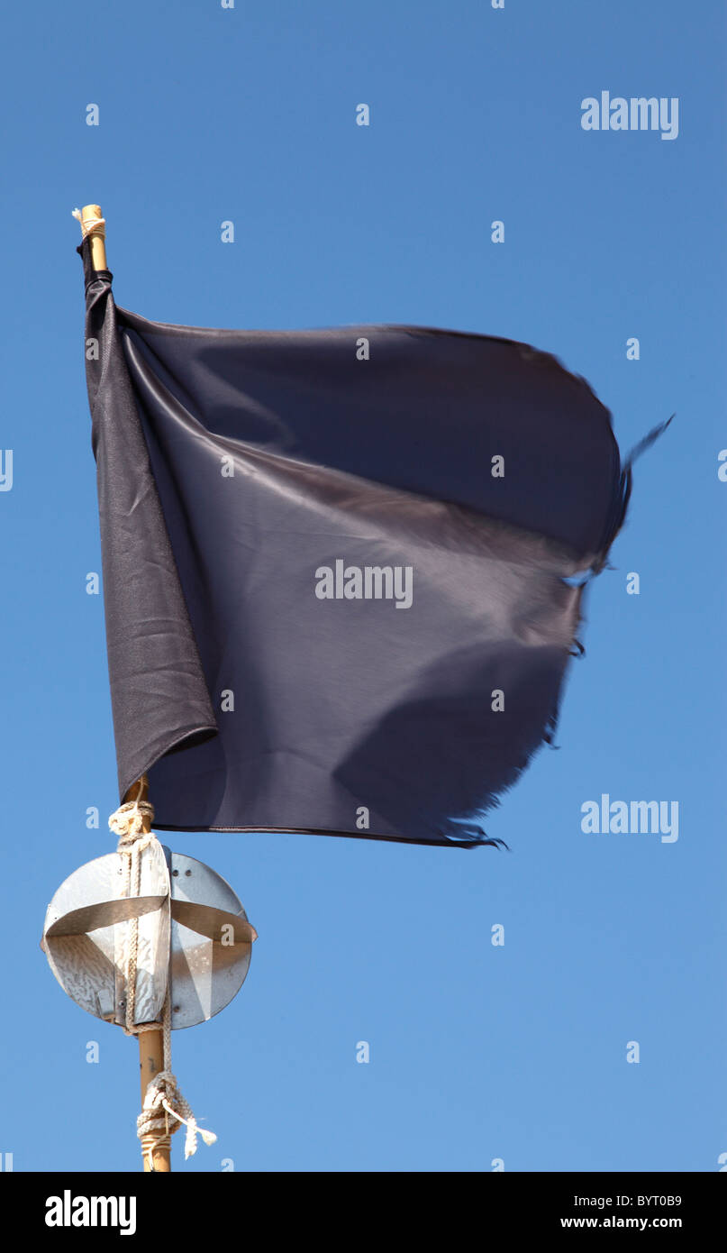 schwarze Flagge vor blauem Himmel Stockfoto