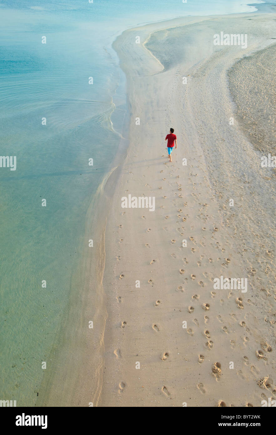 Mann zu Fuß am Strand neben dem Hotel Burj Al Arab, Dubai, Vereinigte Arabische Emirate. Stockfoto