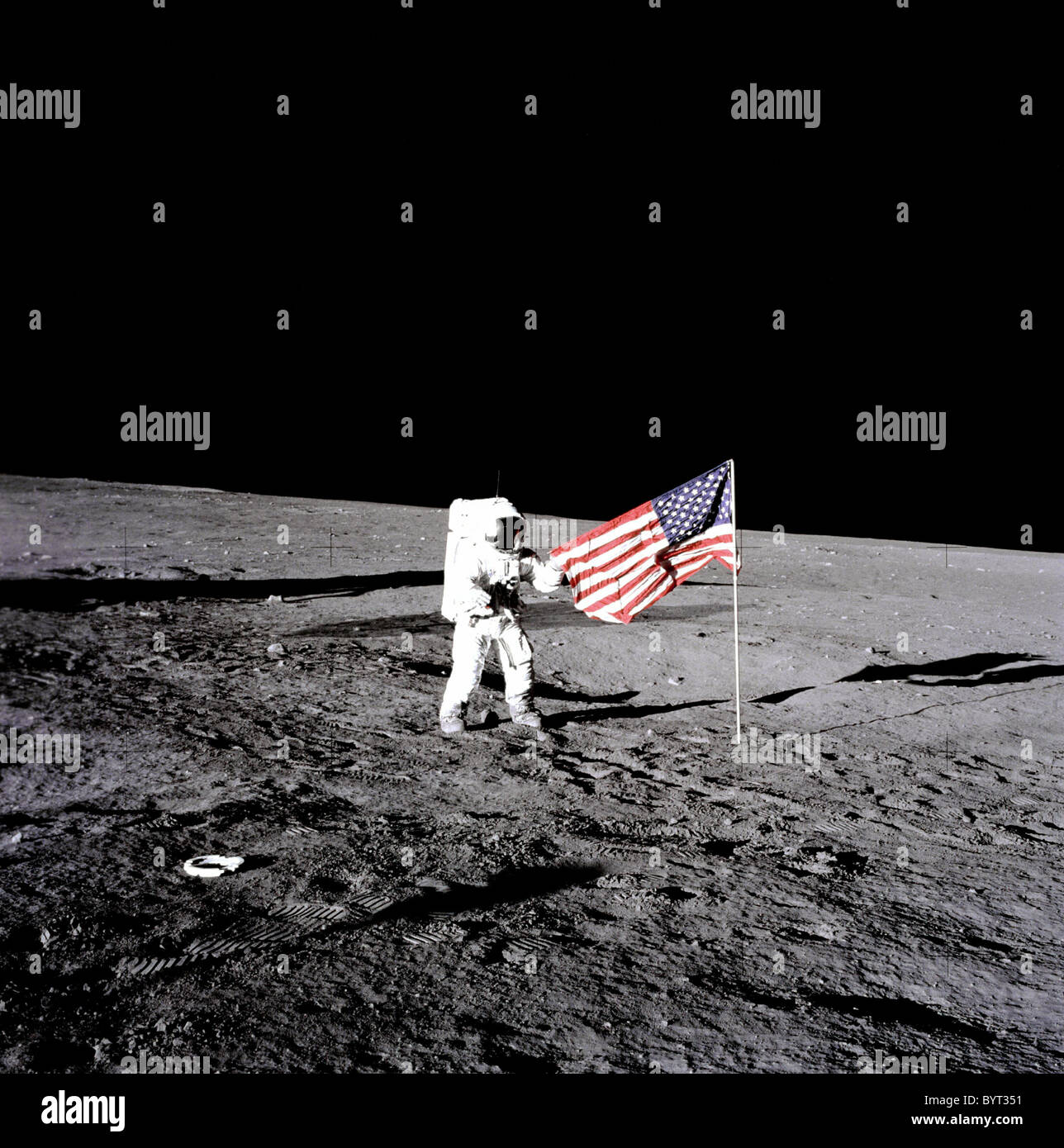 Apollo 12 Astronauten Charles "Pete" Conrad steht neben der USA-Flagge auf dem Mond. Stockfoto